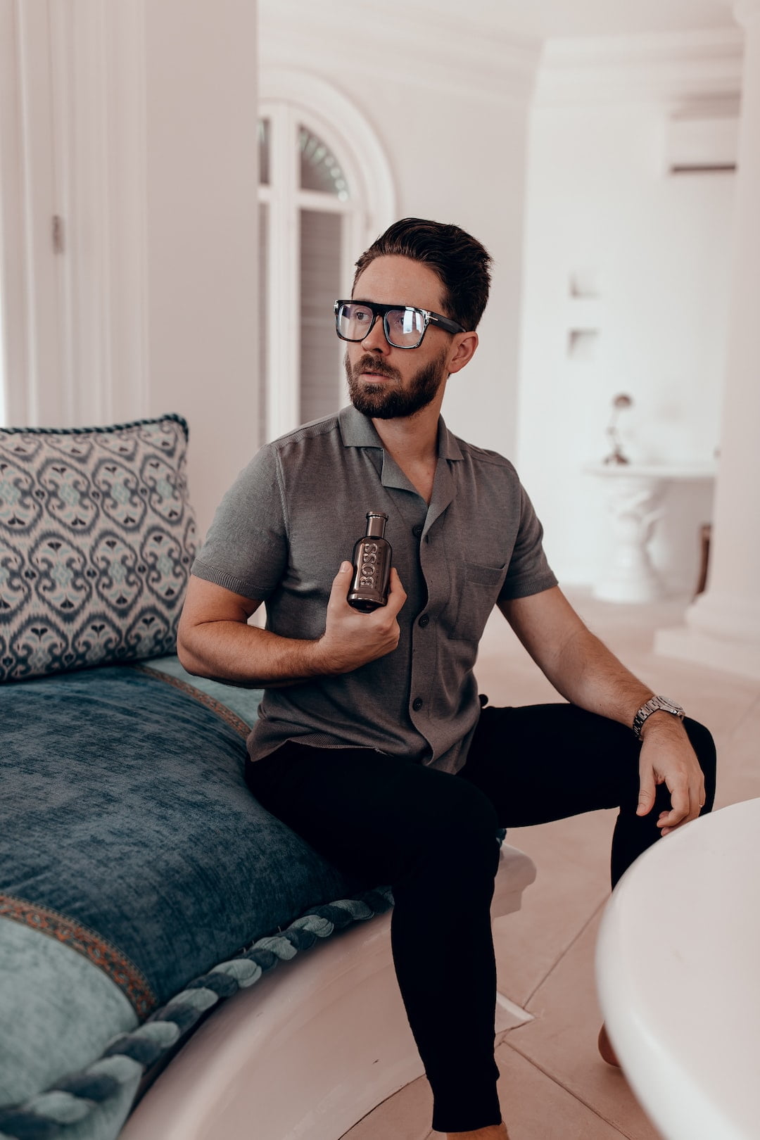 man in gray crew neck t-shirt and black pants sitting on blue and white floral